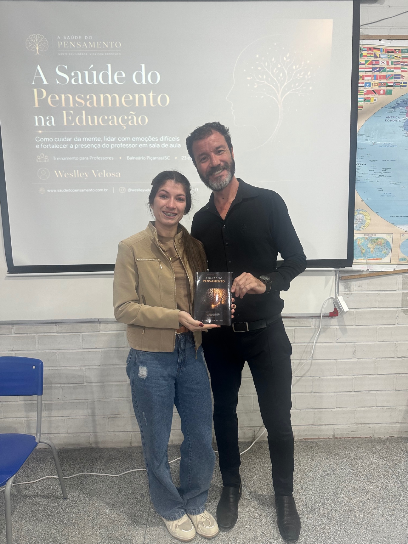 Weslley Velosa com participante do treinamento e o livro A Saúde do Pensamento