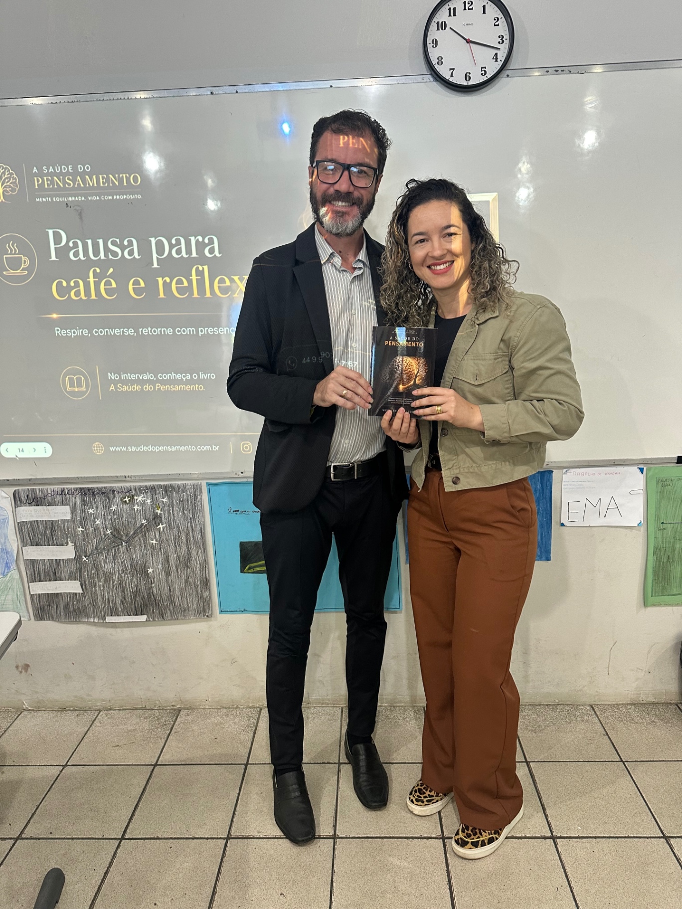 Weslley Velosa e participante segurando o livro A Saúde do Pensamento durante o intervalo