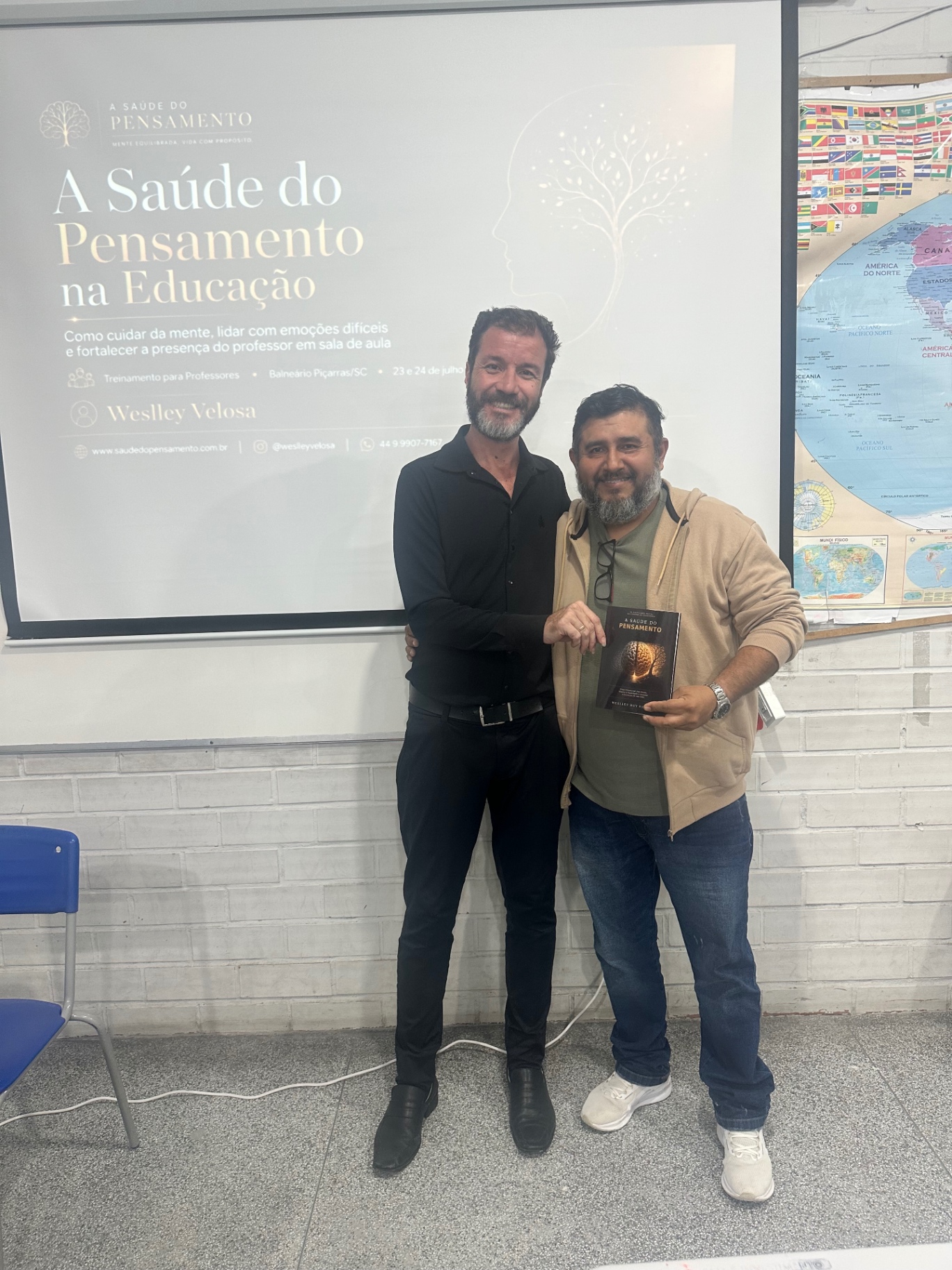 Weslley Velosa e professor participante segurando o livro A Saúde do Pensamento