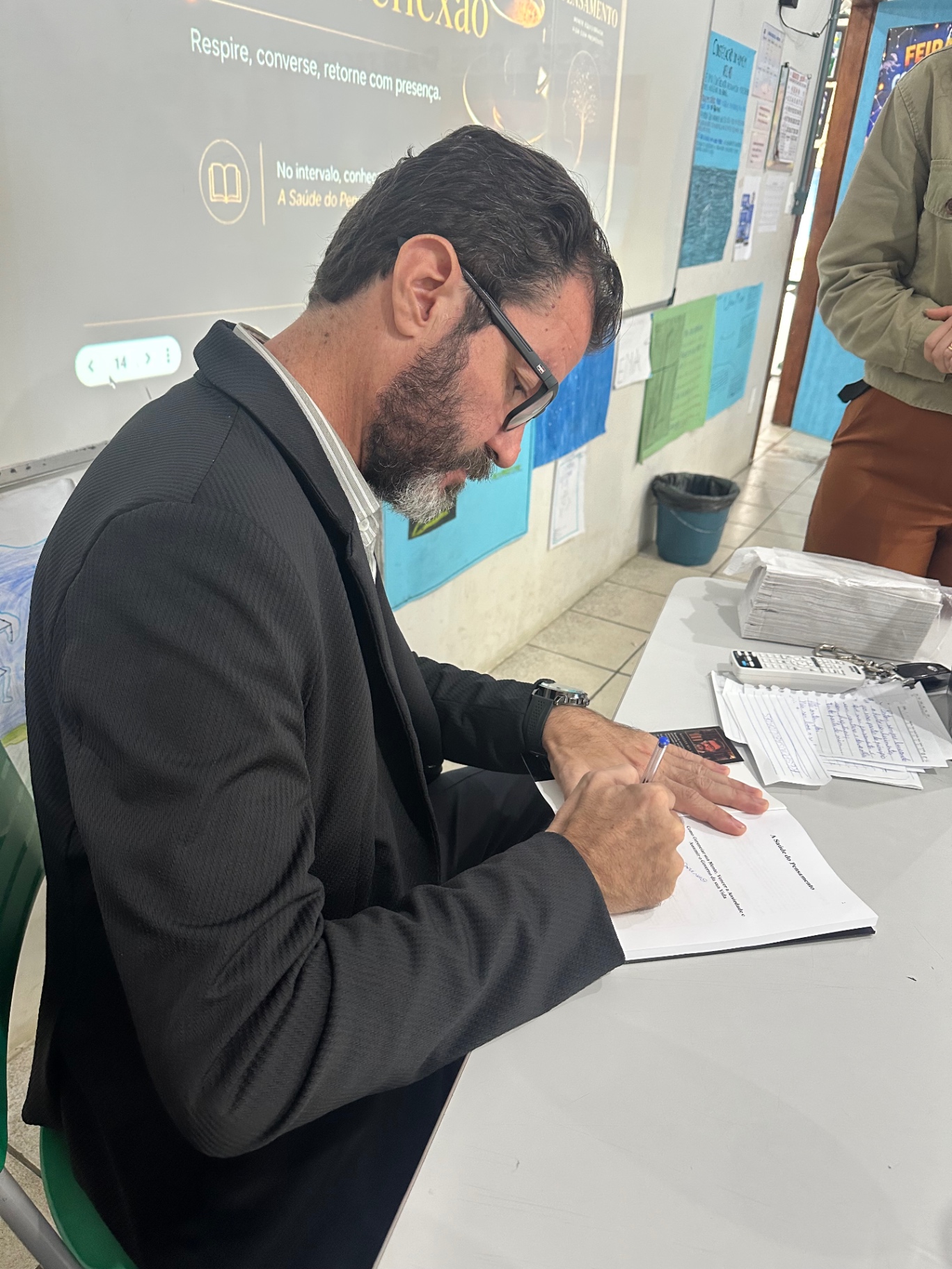 Weslley Velosa escrevendo dedicatória personalizada em exemplar do livro